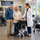 Older couple comparing a transport wheelchair with a mobility specialist in a medical equipment store